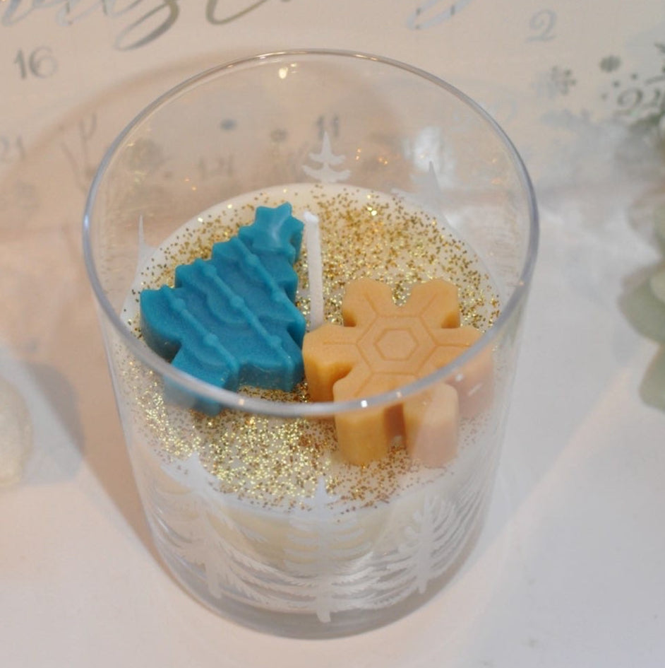 Decorative glass with Christmas-themed items on a festive background